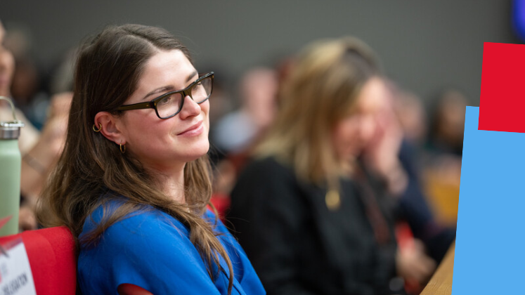 A woman sits in the crowd at an event