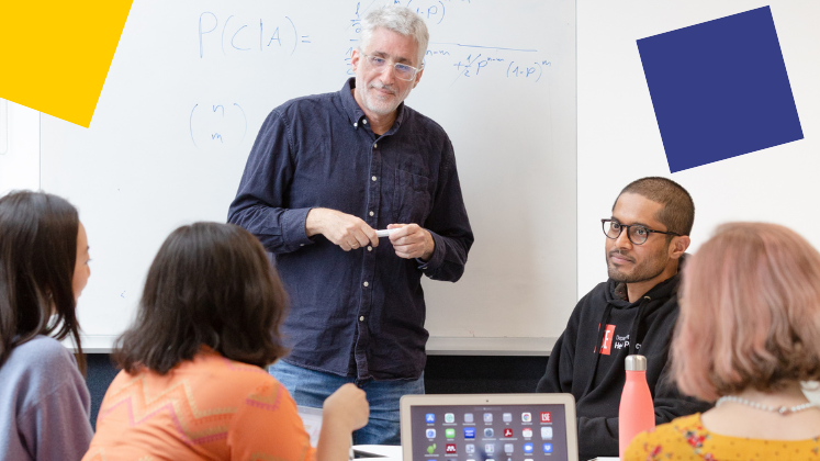 A workshop with a table of 4 students and a man leading the session