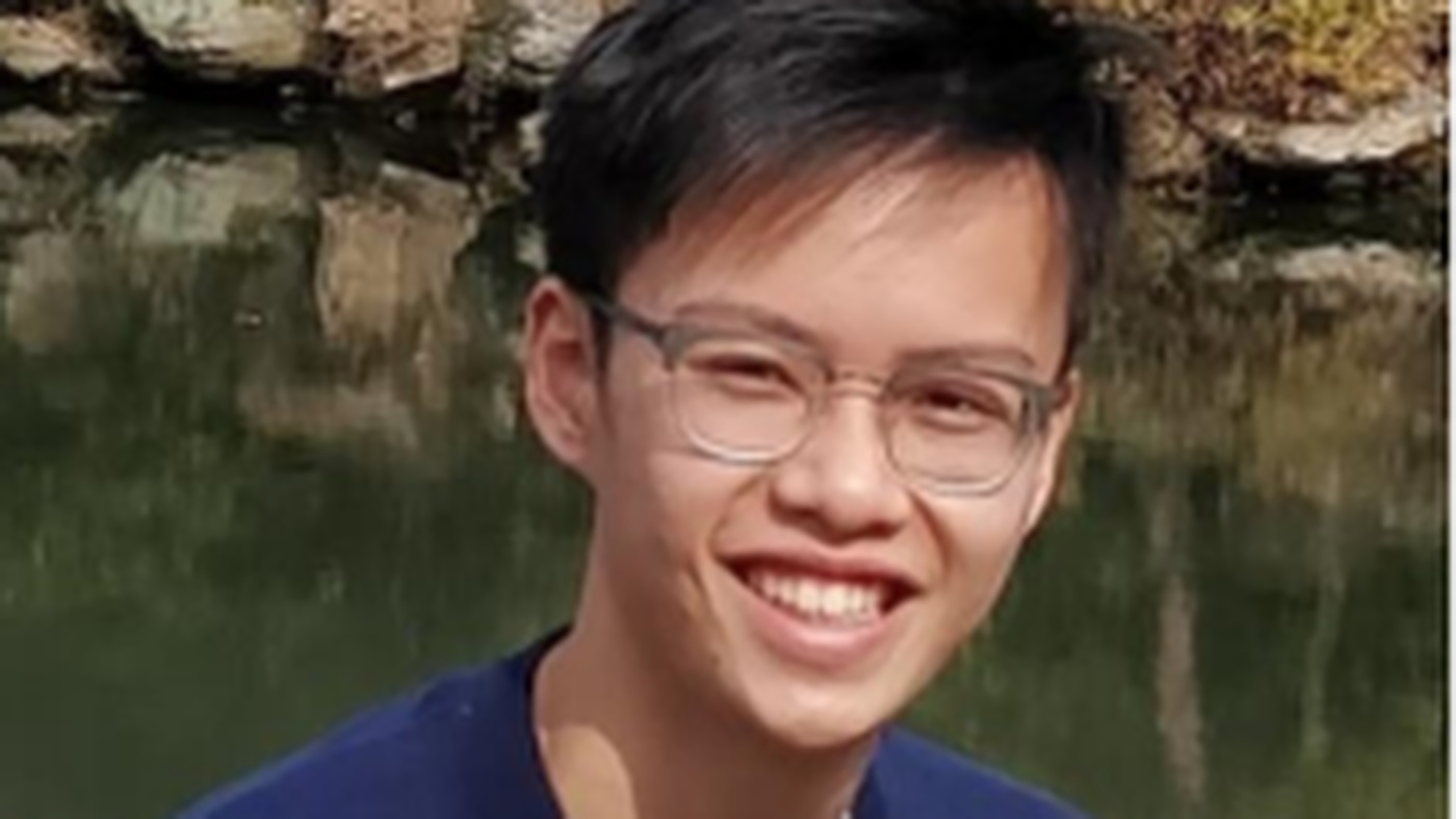 A man wih glasses in front of a pond
