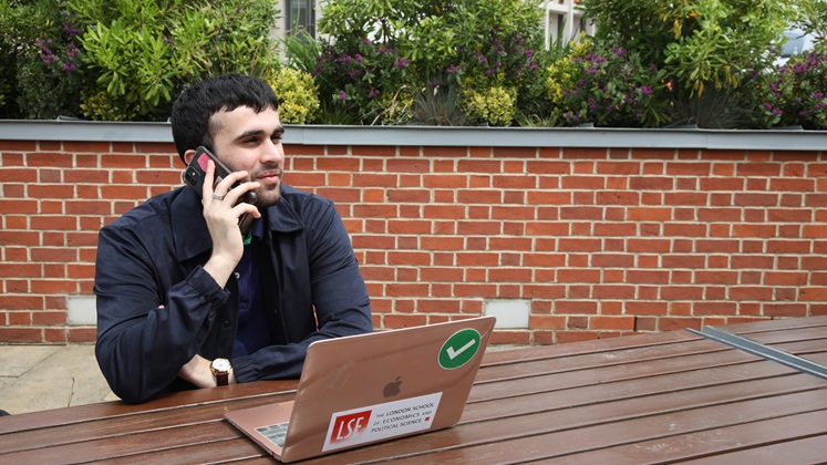 Student using phone  on SAW terrace