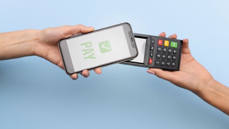 person-paying-with-its-smartphone-wallet-app 747x420